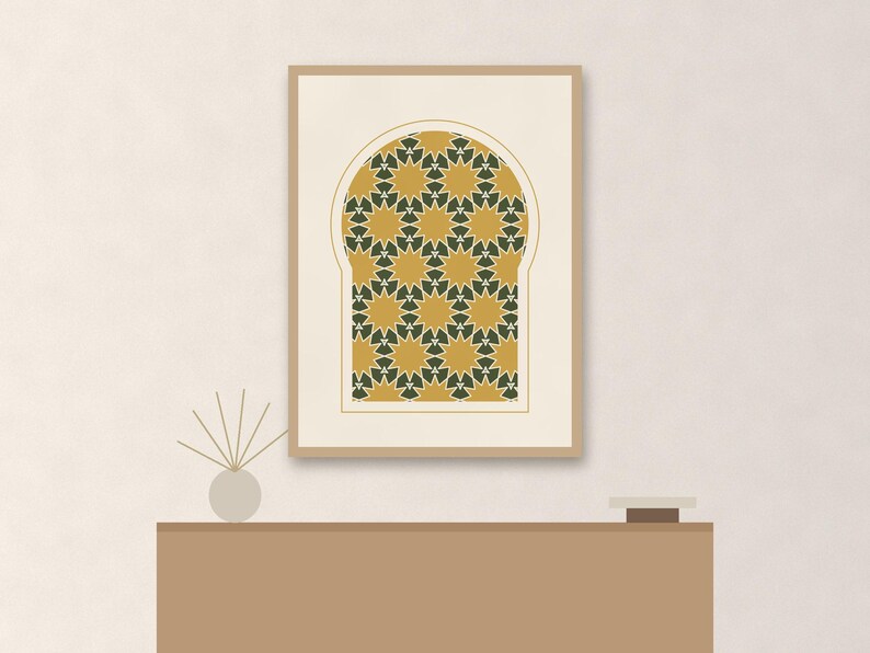 May include: A rectangular framed wall art print featuring an arched window shape filled with a repeating geometric pattern of mustard yellow and dark green stars on a cream background, displayed in a light wood frame with a thin white mat border.