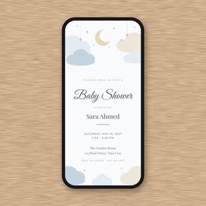 Peut inclure: Une invitation num&eacute;rique pour une f&ecirc;te pr&eacute;natale affich&eacute;e sur un &eacute;cran de smartphone avec un fond blanc, des nuages bleu clair et beige, un croissant de lune et des &eacute;toiles. Le texte indique : Please join us for a Baby Shower honoring Sara Ahmed, Saturday, May 15, 2027, 2:00 - 5:00 PM, The Garden Room, 123 Main Street, Your City, RSVP to Fatima 555 123 4567.