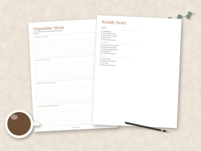 May include: Two white paper planners with black text and terracotta headings. One sheet is titled Dopamine Menu with sections for 5 minutes, 30 minutes, and longer tasks. The other is a Weekly Reset checklist with home, life, and me categories.