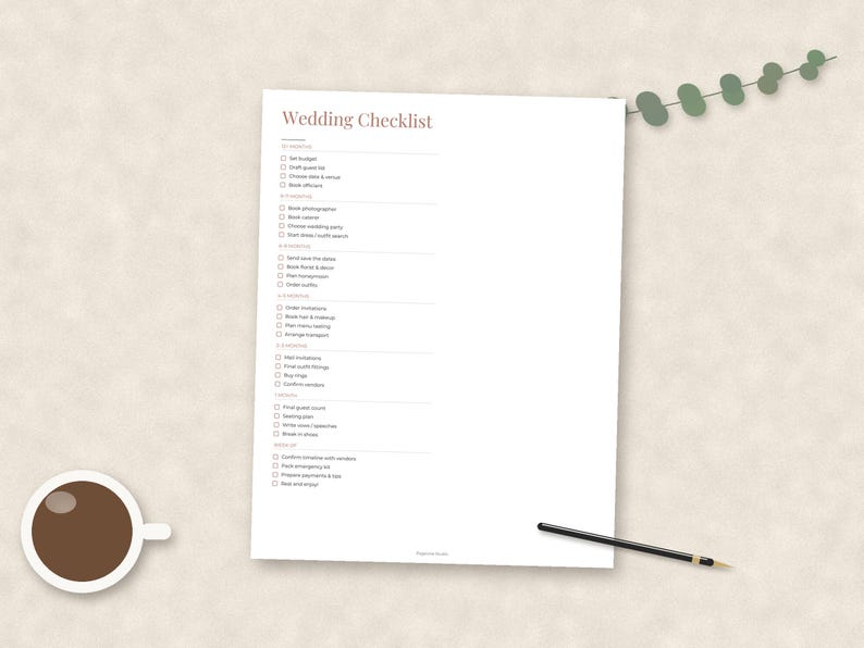 May include: A white paper sheet featuring a printed Wedding Checklist with various tasks organized by timeline, from 12+ months to the wedding day. The document includes checkboxes for each item, a cup of black coffee, and a thin black pen.