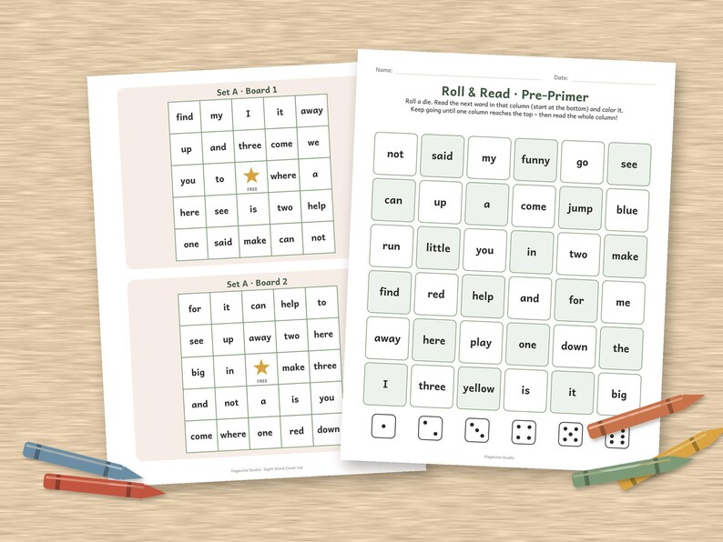 May include: Educational worksheets featuring Roll & Read Pre-Primer word grids with columns of sight words and dice icons at the bottom. Two smaller boards labelled Set A Board 1 and 2 are included, with colourful crayons placed around the pages.