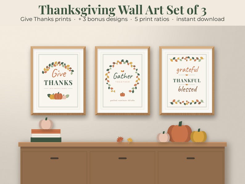 May include: A set of three framed wall art prints featuring Thanksgiving themes. The prints display the text Give THANKS, Gather TOGETHER, and grateful THANKFUL blessed, decorated with autumn-coloured leaf wreaths and small pumpkin illustrations.