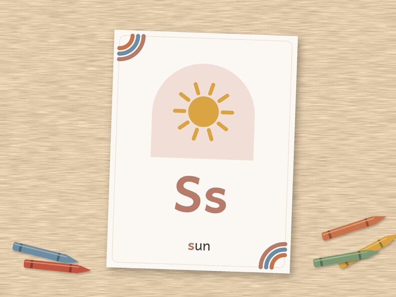 May include: A rectangular educational flashcard featuring the letter S in both uppercase and lowercase, a yellow sun icon inside a pale pink arch, and the word sun printed below. The card has small rainbow corner accents in blue and orange.
