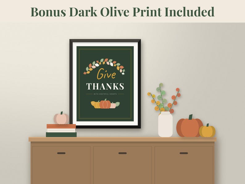 May include: A framed wall art print featuring a dark green background with the text Give THANKS with grateful hearts. The design includes a colourful autumn leaf wreath at the top and a row of pumpkins at the bottom. Text reads Bonus Dark Olive Print Included.