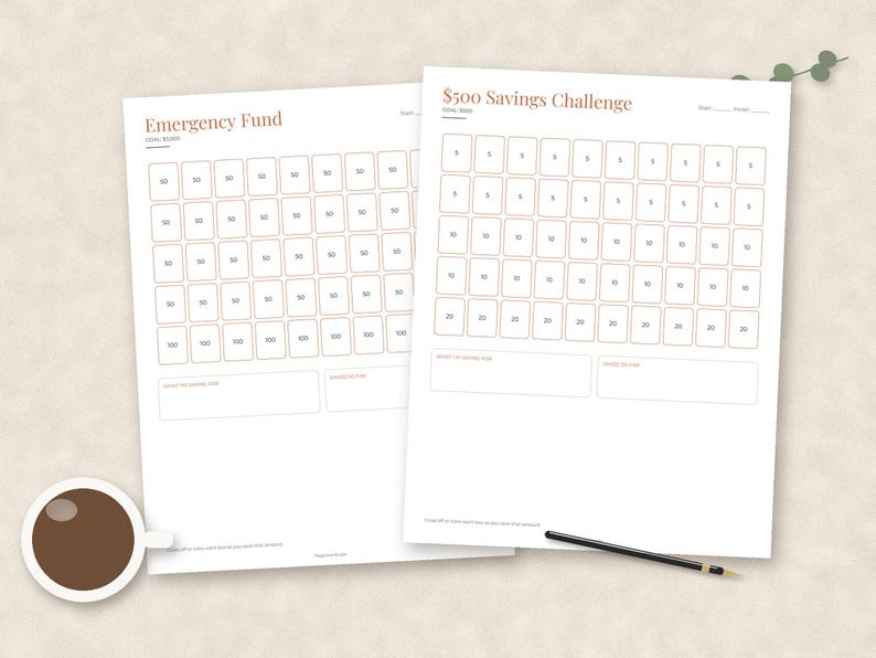 May include: Two white paper savings tracker sheets with rust-colored text and borders. One sheet is titled Emergency Fund, the other $500 Savings Challenge. Both feature grids of numbered boxes for tracking progress, with blank fields for goal dates and amounts.