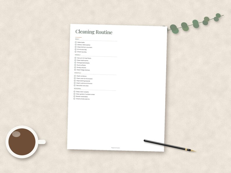 May include: A white paper cleaning routine checklist with black text organized into daily, weekly, monthly, and seasonal sections. The document features checkboxes for each task, a cup of black coffee, and a black pen placed on the page.