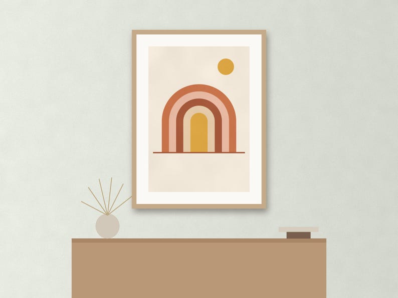 May include: A framed wall art print featuring a graphic illustration of a multi-colored rainbow arch in shades of terracotta, pink, and yellow, with a solid yellow circle representing the sun, all set against a light cream background.