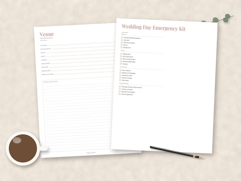 May include: Two white paper sheets featuring black text and lines. One sheet is titled Venue with contact fields and a notes section. The other sheet is titled Wedding Day Emergency Kit with a checklist of items. A coffee cup and pen are visible.