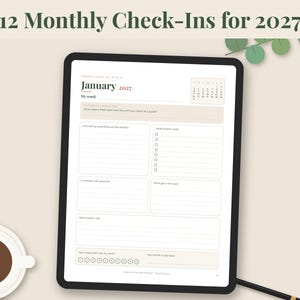 May include: A digital tablet displaying a January 2027 monthly check-in planner page with lined sections for reflection, a small calendar, and a progress tracker. The text 12 Monthly Check-Ins for 2027 is visible at the top of the screen.