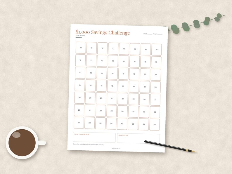 May include: A white paper savings tracker sheet titled $1,000 Savings Challenge with a grid of boxes containing various dollar amounts. The document includes fields for start and finish dates, a goal of $1,000, and sections for savings notes.