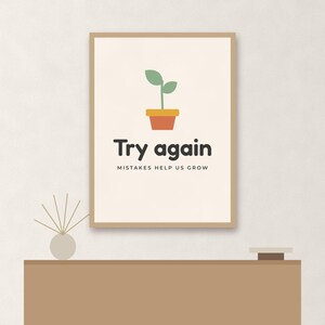 May include: A framed wall art print featuring a small green plant in a terracotta pot. Below the plant, the text reads "Try again" in large dark letters, followed by the smaller text "MISTAKES HELP US GROW" on a light cream background.