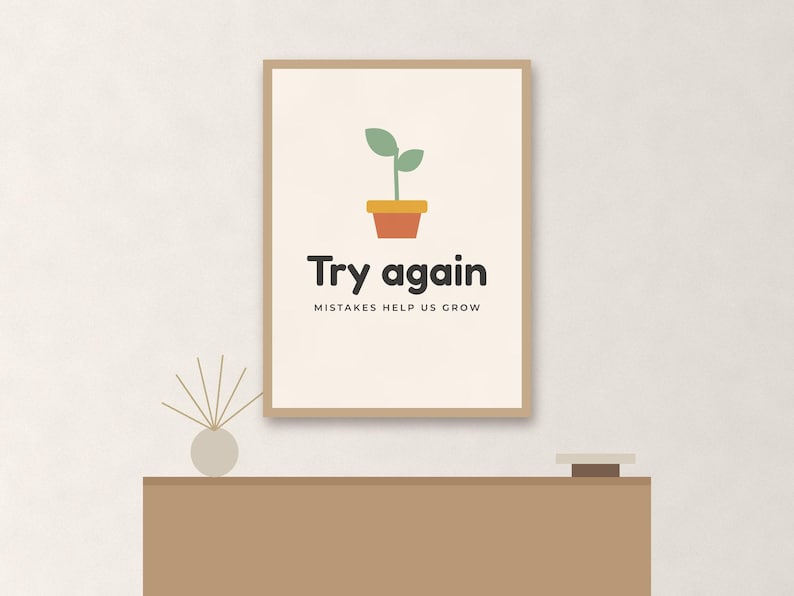 May include: A framed wall art print featuring a small green plant in a terracotta pot. Below the plant, the text reads "Try again" in large dark letters, followed by the smaller text "MISTAKES HELP US GROW" on a light cream background.
