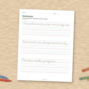 May include: A white educational worksheet for handwriting practice with the title Sentences, featuring three lines of cursive text to trace and blank lines below each, accompanied by five colorful crayons scattered around the page.