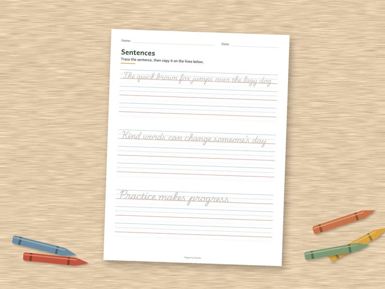 May include: A white educational worksheet for handwriting practice with the title Sentences, featuring three lines of cursive text to trace and blank lines below each, accompanied by five colorful crayons scattered around the page.