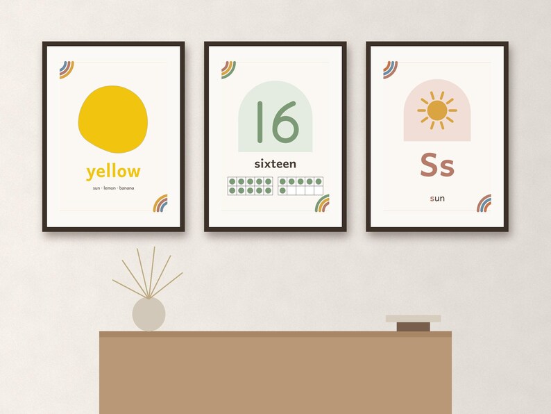 May include: Three framed educational wall art prints featuring a yellow circle with the word yellow, the number 16 with a ten-frame, and the letter Ss with a sun icon. Each print includes small rainbow accents in the corners on white backgrounds.