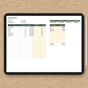 May include: A digital tablet displaying a Paycheck 1 budget tracker spreadsheet with columns for bills, due dates, and amounts, alongside a spending summary table. A white stylus is positioned vertically to the right of the black-framed tablet.