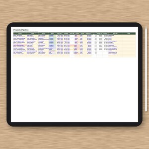 May include: A black tablet displaying a Projects Pipeline spreadsheet with columns for project, client, service, status, dates, priority, pricing, quoted fee, hours, and invoiced amounts, accompanied by a white stylus resting on the right side.