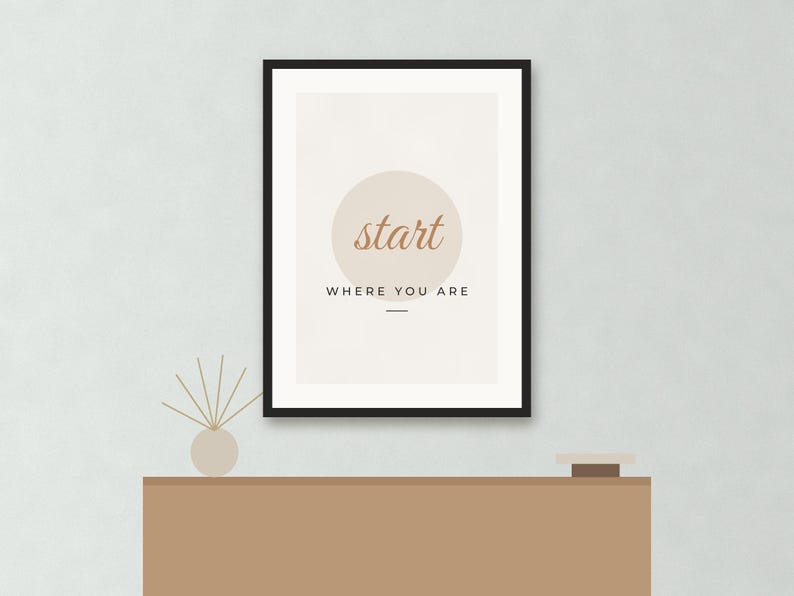 May include: A framed wall art print featuring a beige background with a large light tan circle in the center. The text "start" is written in a brown cursive font inside the circle, with "WHERE YOU ARE" printed in black capital letters below it.