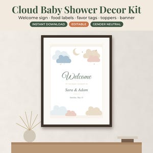 May include: A framed welcome sign for a baby shower featuring the text Cloud Baby Shower Decor Kit, Welcome, to the baby shower of Sara & Adam, Saturday, May 15. The design includes illustrations of blue, pink, and beige clouds, a moon, and stars.