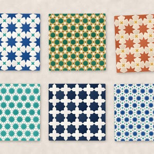 May include: A set of six square coasters featuring various geometric star and cross patterns in blue, white, green, yellow, and terracotta. Each coaster displays a repeating symmetrical design with sharp angles and contrasting color combinations.