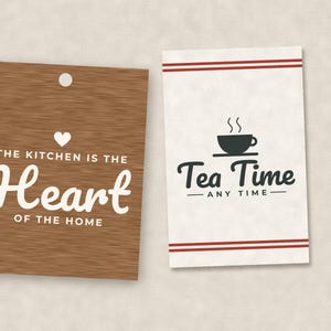 May include: Two rectangular tags. The left tag has a brown wood grain texture, a white heart icon, and the text THE KITCHEN IS THE HEART OF THE HOME. The right tag is white with two red horizontal stripes and the black text Tea Time ANY TIME.