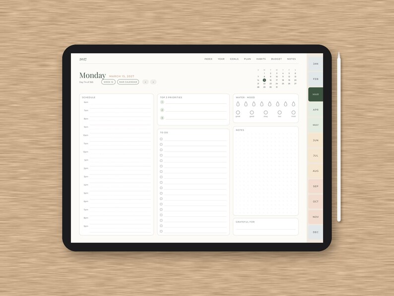 Puede incluir: Una tableta digital que muestra una interfaz de planificador diario con un horario, lista de tareas, rastreador de h&aacute;bitos y secci&oacute;n de notas. La pantalla muestra el texto Monday, March 15, 2021, y una barra lateral con los meses de enero a diciembre.