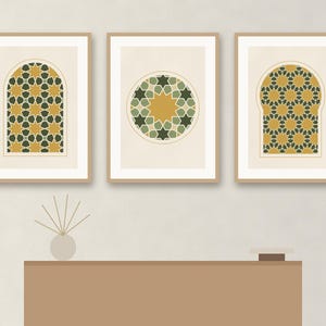 May include: Three framed wall art prints featuring geometric star patterns in shades of mustard yellow, dark green, and cream. The two outer prints are set within arched window shapes, while the center print displays a circular star motif.