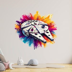 May include: A white and grey Millennium Falcon spaceship illustration with a colourful paint splash background in pink, yellow, blue, and purple. The spaceship has detailed features and is a popular science fiction icon.