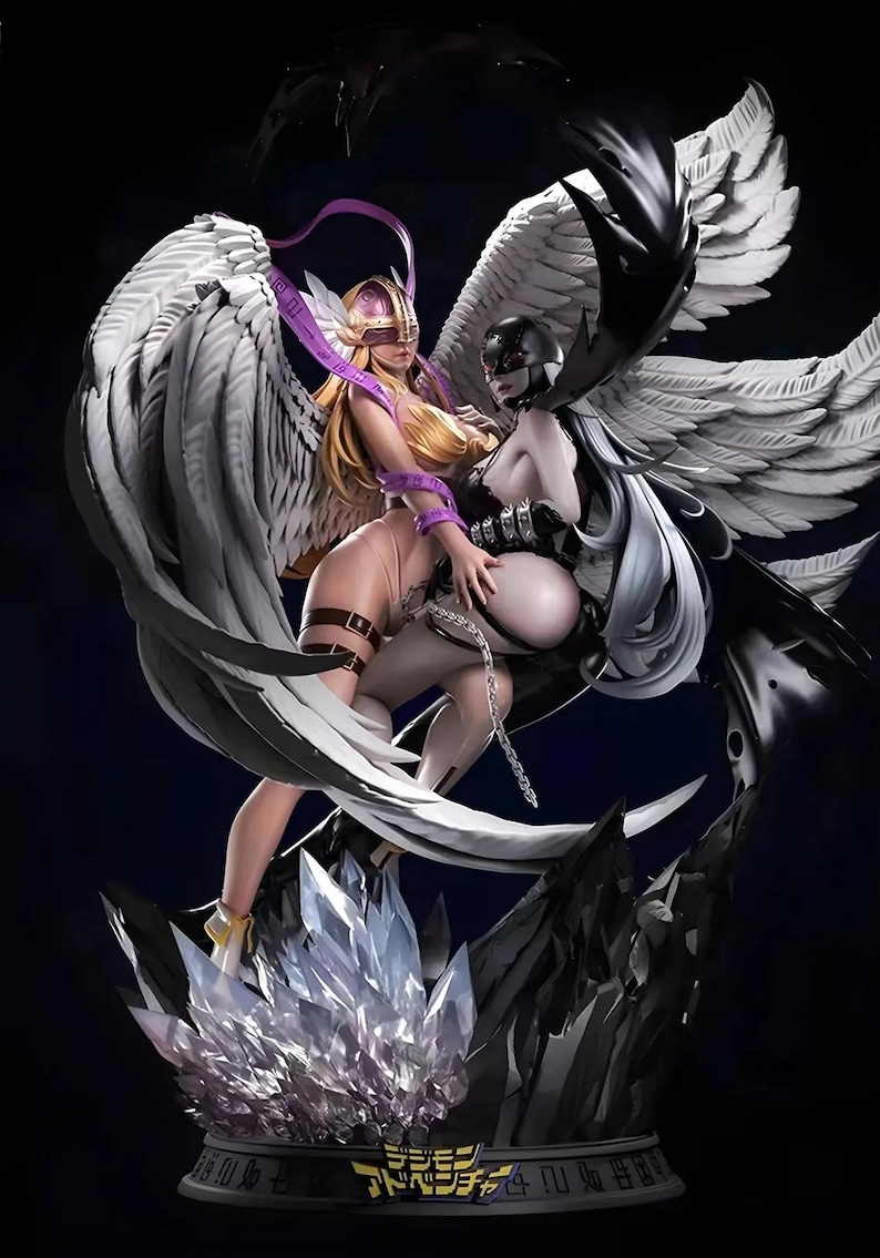 May include: A detailed figurine of two figures with large wings. One figure has blonde hair and a gold helmet, the other has black hair and a black helmet. The base is decorated with crystals and the Digimon Adventure logo.