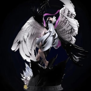 May include: A detailed figurine of a figure with long white hair, black and white wings, and a black outfit. The figure is posed on a dark, rocky base with crystal accents. The wings are spread wide, creating a dramatic contrast.