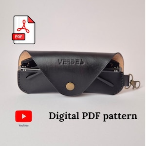 Op de afbeelding: Zwarte leren brillenkoker met het woord "VERDE'S" in reliëf op de voorkant. De koker is open en onthult een bril erin. Een PDF-pictogram en de woorden "Digital PDF pattern" zijn ook zichtbaar.