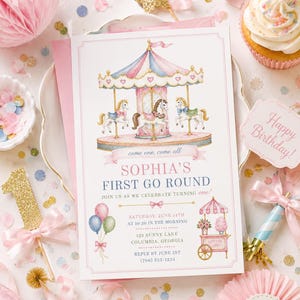 Può includere: Un invito di compleanno a tema giostra, rosa e bianco, con il testo "Sophia's First Go Round". Il design include un'illustrazione della giostra, palloncini e un carretto di zucchero filato. Sono visibili anche un cupcake e un cartello "Happy Birthday".