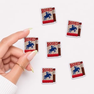 May include: Six rectangular embroidered patches featuring a tan background, a red border, and the word RODEO in red text above a blue silhouette of a person riding a bucking horse, with a brown vertical stripe on the right side of each patch.