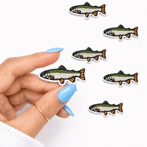 May include: Embroidered fish patches with green, white, and orange details. The patches feature a detailed design of a fish, perfect for adding to clothing or accessories. The patches are small and have a white border.