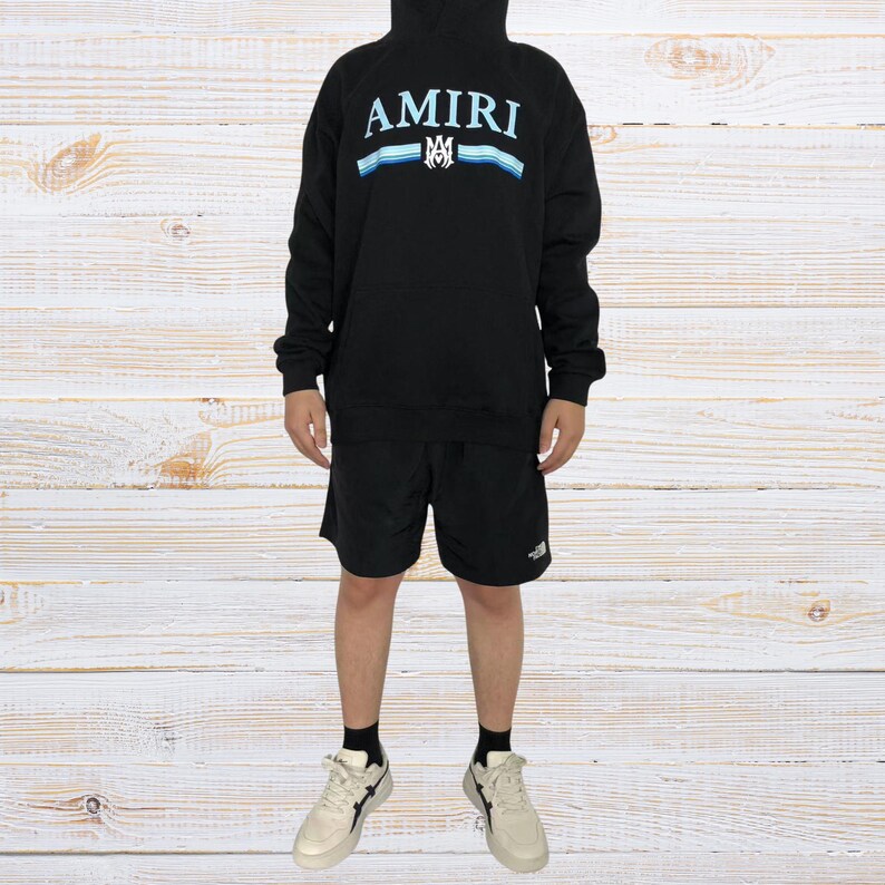 Unisex AMIRI-style hoodies in black and white with bold front graphic and stripe design, pullover streetwear sweatshirts with hood and kangaroo pocket.