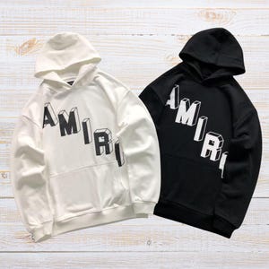 Unisex oversized AMIRI graphic hoodie in black and white streetwear style