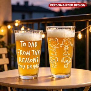 May include: Two personalized pint glasses filled with beer, sitting on a table. One glass reads "To Dad From The Reasons You Drink." The other glass features cartoon drawings of a boy, a girl, a cat, and a dog, with names below.