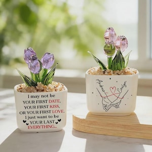 May include: Two small, square white ceramic pots with glass tulip flowers. One pot has the text "I may not be your first date..." The other pot has the names "Andrew" and "Evelyn" with a heart and hands illustration. The pots sit on a wooden tray.