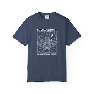 Puede incluir: Camiseta azul marino con un gráfico blanco de una hoja de cannabis, líneas geométricas y el texto "NATURAL GEOMETRY CALCULATED TO HELP YOU Vibe". La camiseta tiene mangas cortas y cuello redondo.