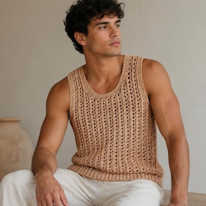 May include: A sleeveless tan crochet tank top featuring a vertical open-knit pattern with a ribbed neckline and hem. The garment is constructed with a textured, breathable stitch design, providing a lightweight appearance and a consistent neutral tone.