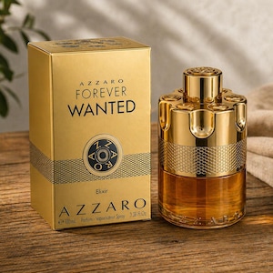 May include: A gold-colored perfume bottle and box set. The box reads "AZZARO FOREVER WANTED" with a circular emblem. The perfume bottle is cylindrical with a gold cap and a textured design. The bottle contains a light brown liquid.