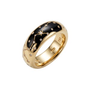 Puede incluir: Un anillo de oro con una incrustación de esmalte negro que presenta un diseño de constelación con pequeños detalles de diamantes. El anillo tiene un acabado pulido y está marcado con "750".