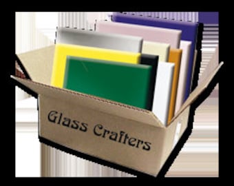 May include: A box labeled "Glass Crafters" filled with various colored glass sheets. The sheets are in shades of green, yellow, white, black, beige, purple, and gray.