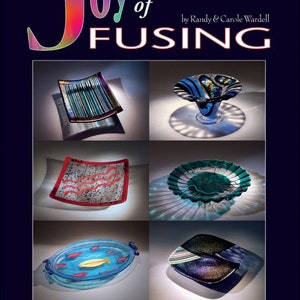 May include: A book titled "Joy of Fusing" by Randy & Carole Wardell, showcasing various fused glass art pieces, including plates, bowls, and a dish with fish designs. The book cover features the title in colorful, stylized lettering and the subtitle "Fusing Basics, Molds & More".