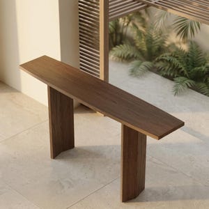 Könnte beinhalten: Ein moderner, minimalistischer Konsolentisch aus Holz mit rechteckiger Platte und zwei vertikalen Stützen. Der Tisch ist aus dunkelbraunem Holz gefertigt und hat ein schlichtes Design. Der Tisch ist ca. 152 cm lang.