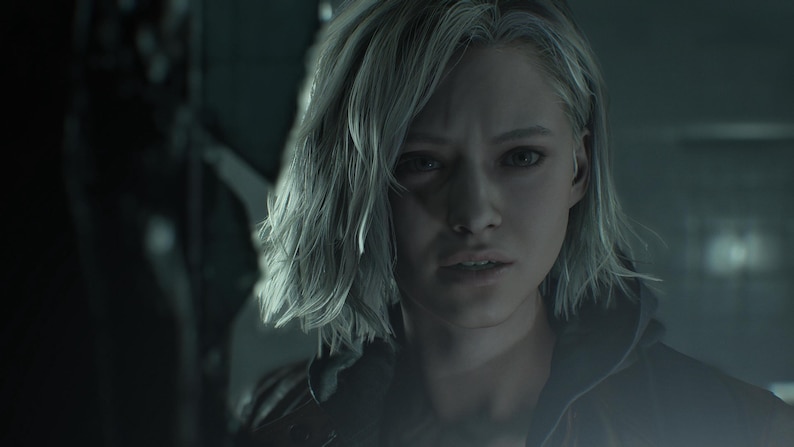 May include: A portrait of a woman with short, grey hair and a worried look. She wears a dark jacket, with a blurred background suggesting an interior. The lighting is subdued, creating a dramatic atmosphere.