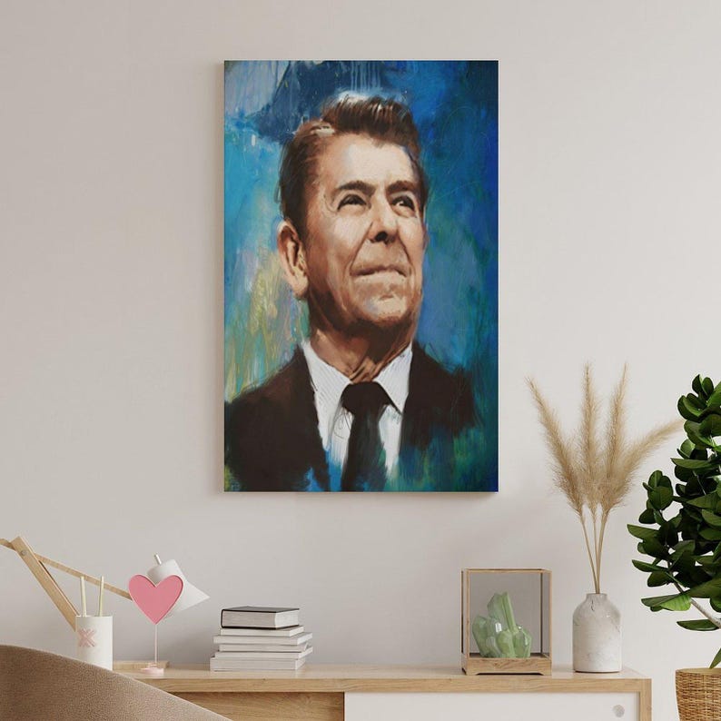 May include: A vertical rectangular wall art print featuring a painted portrait of Ronald Reagan. The subject is depicted from the chest up, wearing a dark suit, white shirt, and black tie, set against a vibrant, textured blue and teal background.