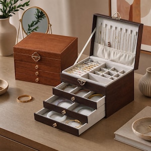 May include: A dark brown wooden jewelry box with a hinged lid and three pull-out drawers. The interior features cream-colored velvet lining, necklace hooks, a pocket, and multiple compartments for rings, bracelets, and other small accessories.