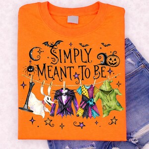 Peut inclure: Un t-shirt orange avec une illustration représentant une corde à linge avec un chien fantôme blanc, un costume rayé violet et noir, une robe patchwork colorée et une créature verte texturée. Le texte indique Simply Meant To Be.