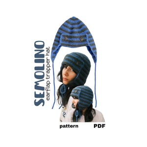 Può includere: Un cappello da trapper all'uncinetto a righe blu e grigio scuro con bottoni laterali e lacci pendenti. Il testo SEMOLINO earflap trapper hat pattern PDF è visibile. Il cappello presenta una lavorazione a maglia testurizzata con paraorecchie e corona arrotondata.
